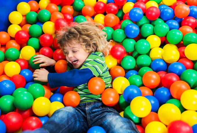 Little boy having fun while playing in the ball pool.