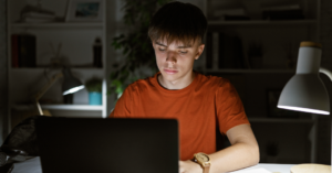 Boy in a dark room on a laptop
